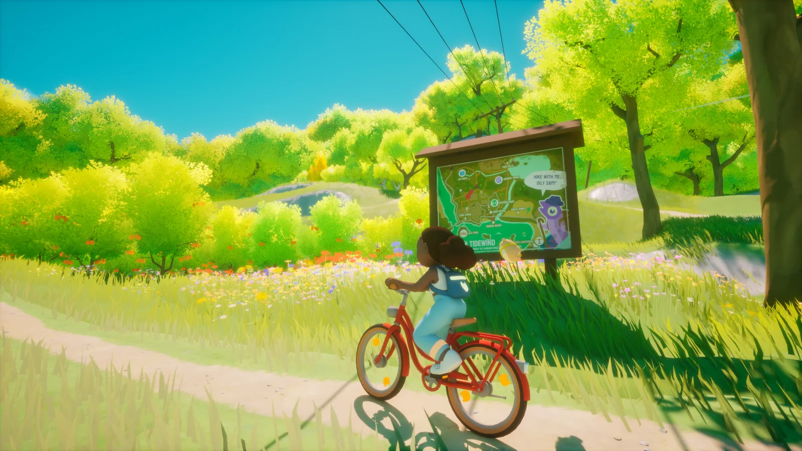 Fiona cycling past a wooden map board of Tidewind on a path through flowering meadows